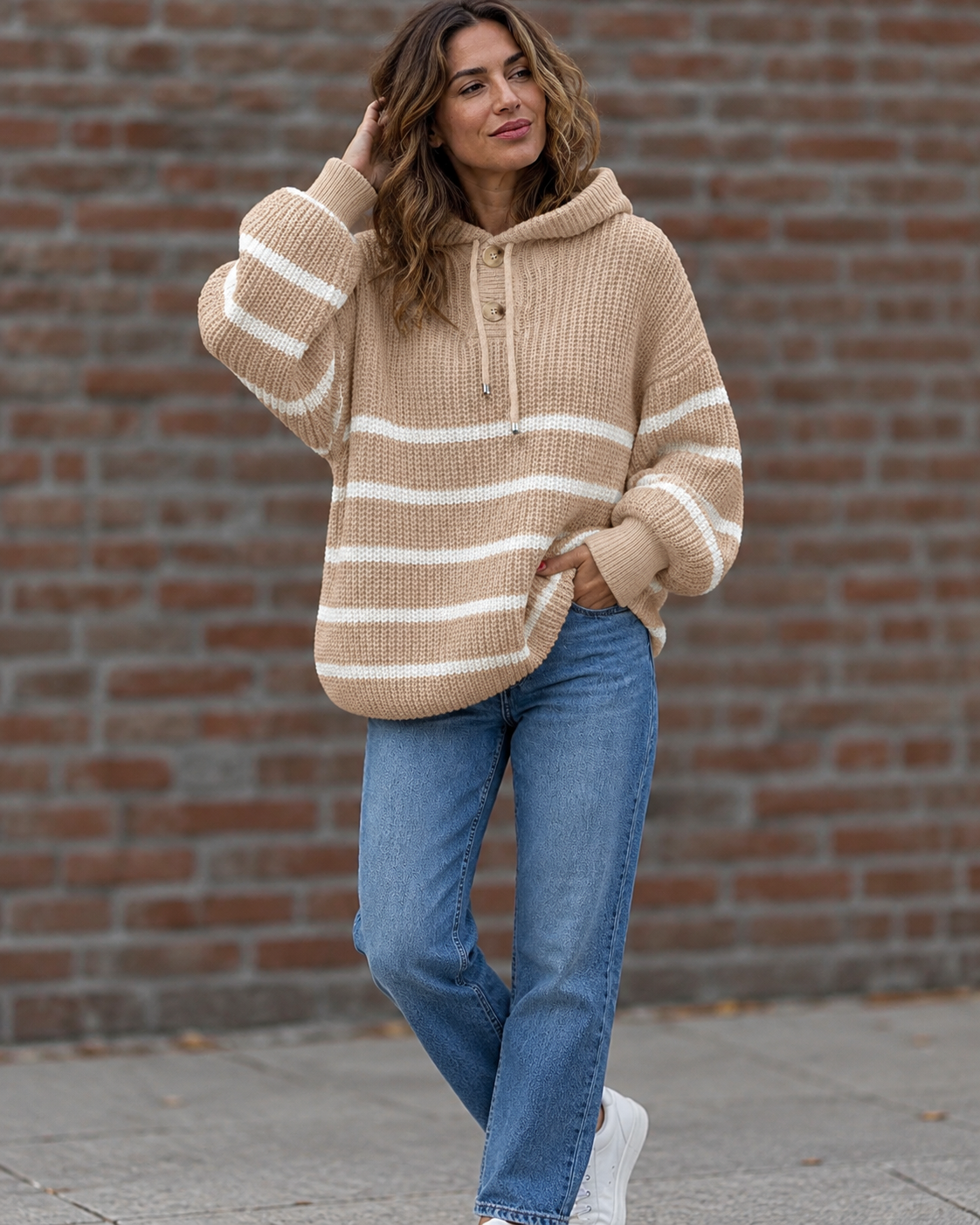Noélla Montréal — gestreepte hoodie khaki, tweede volledige modelfoto, pose bij bakstenen muur