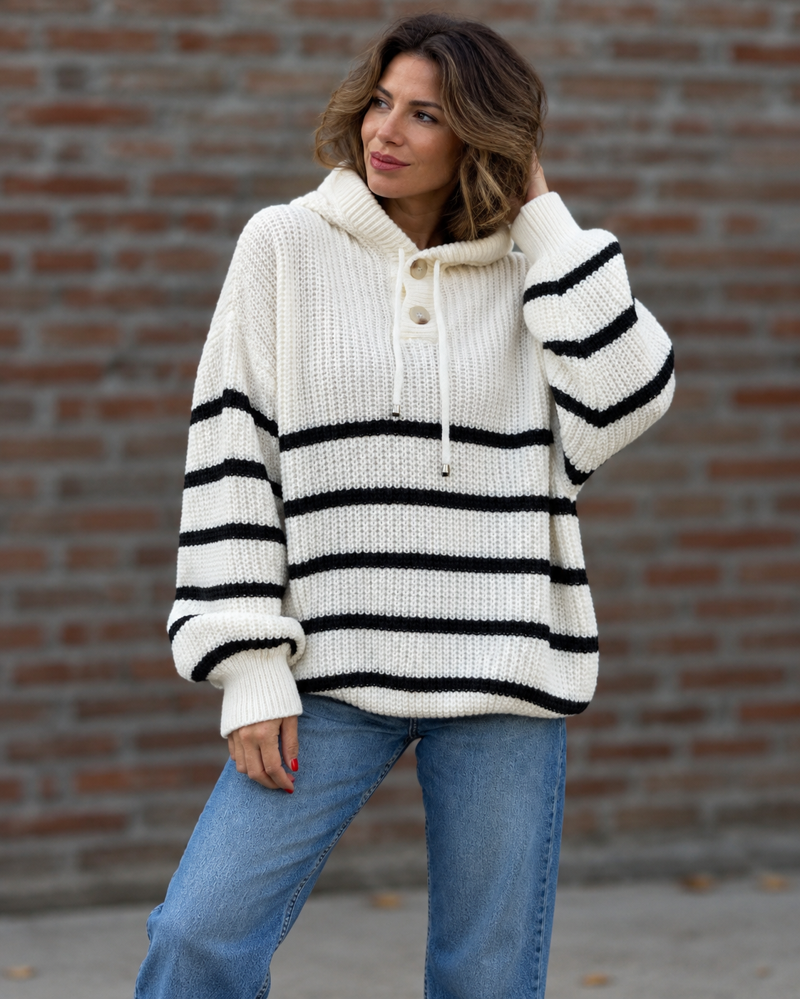 Noélla Montréal — gestreepte hoodie white, tweede volledige modelfoto, pose bij bakstenen muur